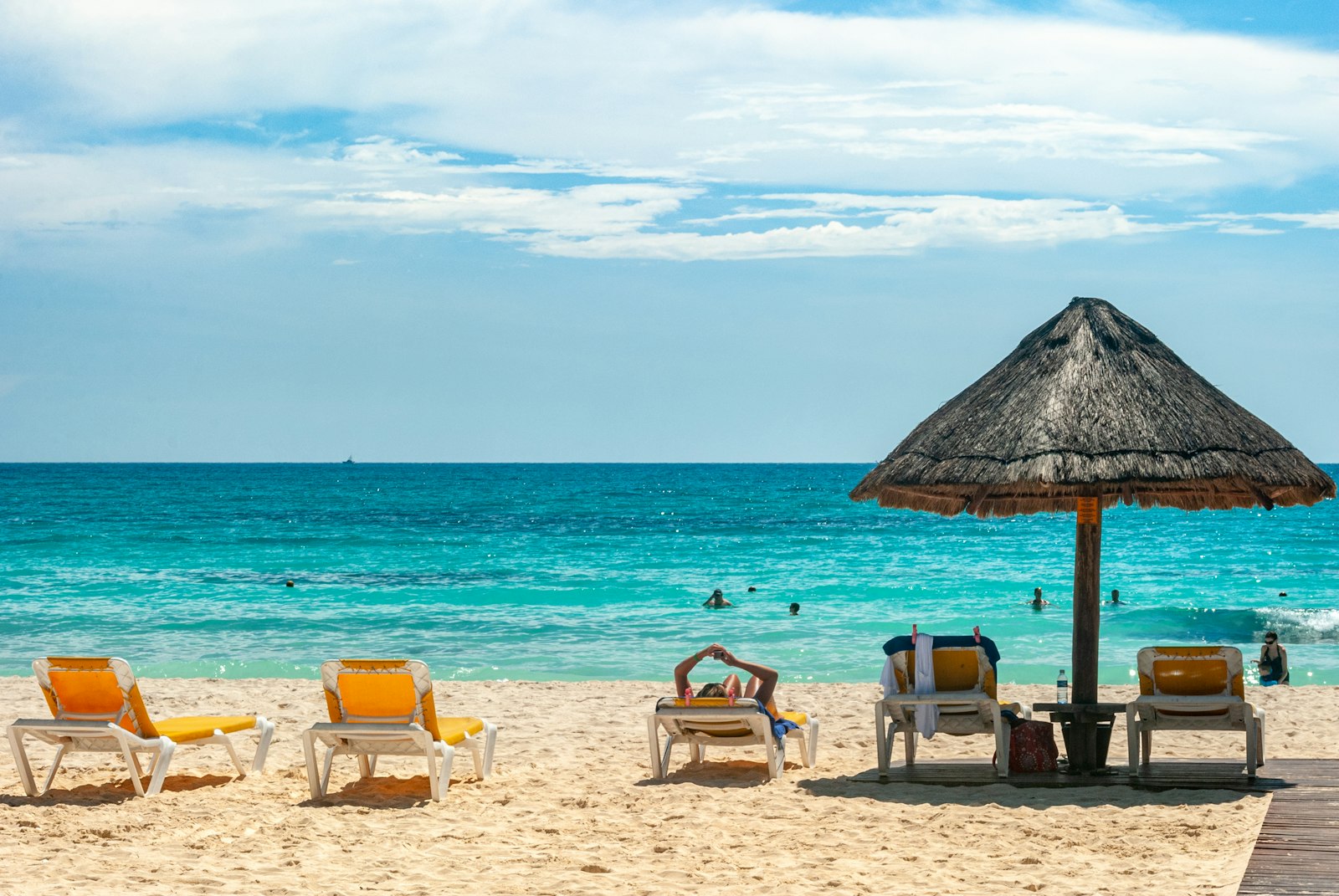 Beach umbrellas on white sand by turquoise water in Cancún, Mexico